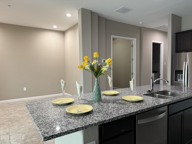 1255 N Arizona Ave Unit 1235, Chandler, AZ 85225 - kitchen featuring stainless steel appliances, dark stone counters, light tile patterned floors, dark cabinets, and recessed lighting