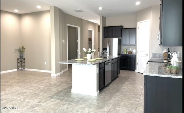1255 N Arizona Ave Unit 1235, Chandler, AZ 85225 - kitchen with appliances with stainless steel finishes, light stone counters, light tile patterned flooring, a center island with sink, and recessed lighting