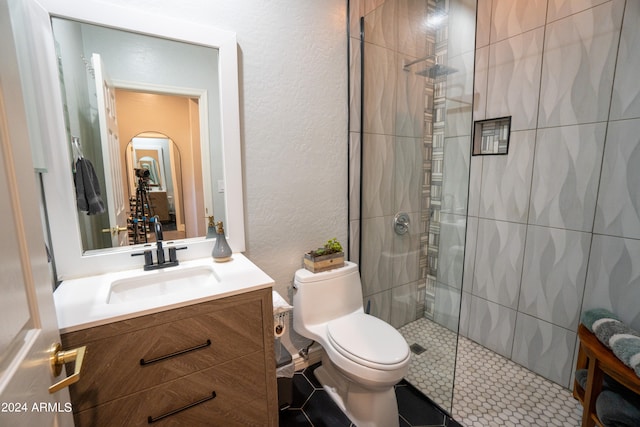 bathroom with vanity, toilet, tile floors, and a shower with door