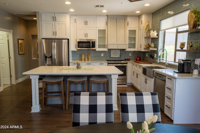 kitchen with a center island, stainless steel appliances, a breakfast bar, and backsplash