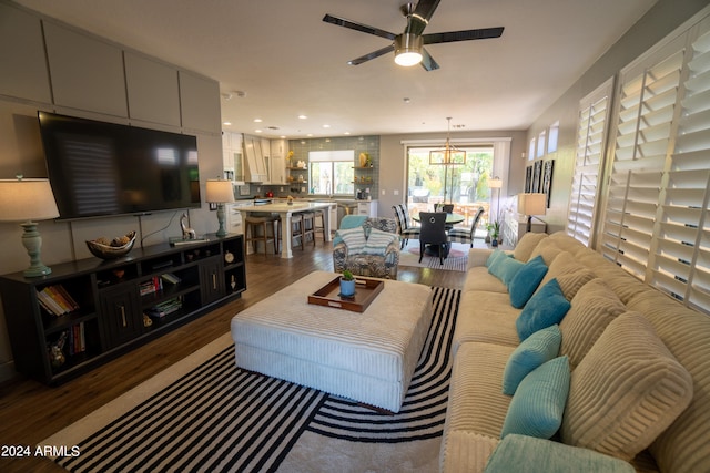 living room featuring hardwood / wood-style flooring and ceiling fan with notable chandelier