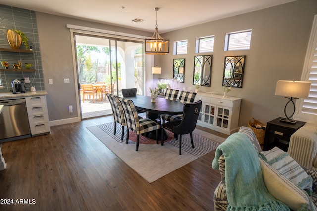 dining area with dark hardwood / wood-style floors and an inviting chandelier