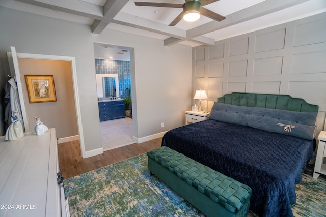 bedroom featuring coffered ceiling, ensuite bathroom, ceiling fan, tile flooring, and beamed ceiling