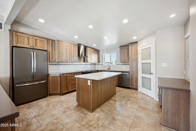 kitchen featuring sink, backsplash, a center island, stainless steel appliances, and wall chimney range hood