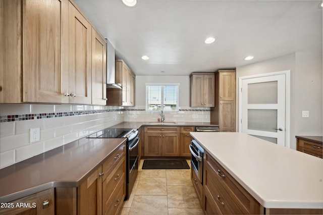 kitchen with tasteful backsplash, sink, light tile patterned floors, stainless steel appliances, and wall chimney exhaust hood