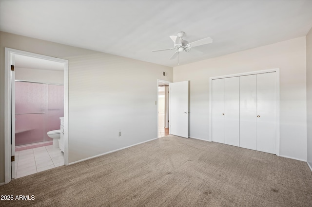 unfurnished bedroom featuring ceiling fan, a closet, connected bathroom, and light carpet