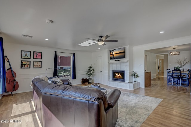 3440 N Meadow Dr, Pine, AZ 85544 - living room featuring ceiling fan, light wood-style flooring, a tiled fireplace, and recessed lighting
