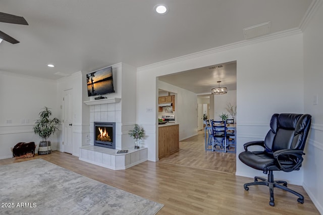 3440 N Meadow Dr, Pine, AZ 85544 - living area with a tiled fireplace, light wood-type flooring, crown molding, recessed lighting, and baseboards
