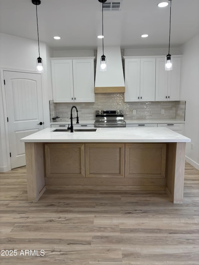3627 W Palmaire Ave, Phoenix, AZ 85051 - kitchen featuring stainless steel range with electric cooktop, a sink, light wood-style flooring, decorative backsplash, and recessed lighting
