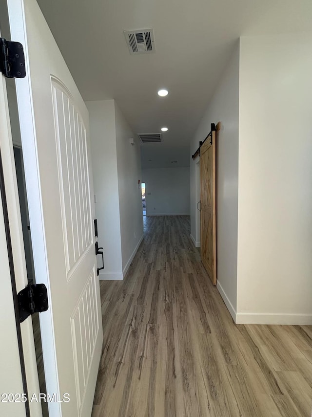 3627 W Palmaire Ave, Phoenix, AZ 85051 - hall featuring light wood-style flooring, a barn door, recessed lighting, and baseboards