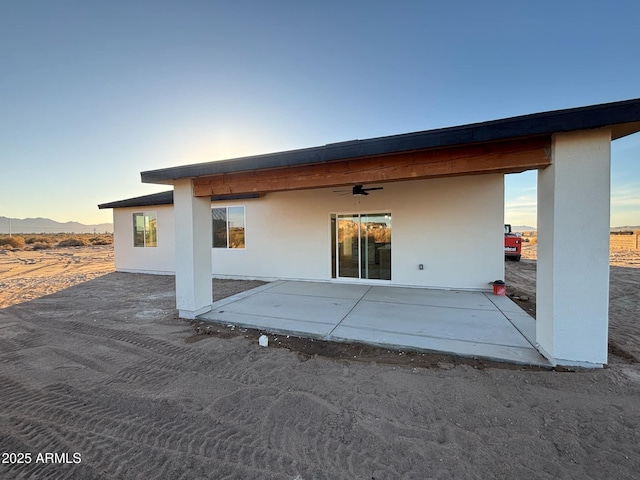 3627 W Palmaire Ave, Phoenix, AZ 85051 - back of house featuring ceiling fan, a patio, stucco siding, and a mountain view