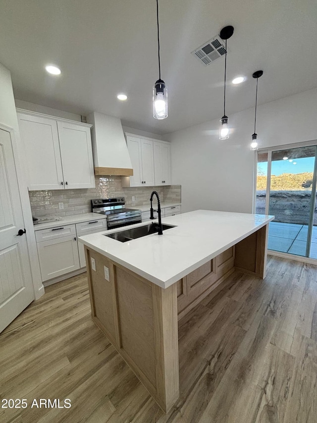 3627 W Palmaire Ave, Phoenix, AZ 85051 - kitchen featuring premium range hood, stainless steel electric stove, a sink, light wood-style floors, and recessed lighting