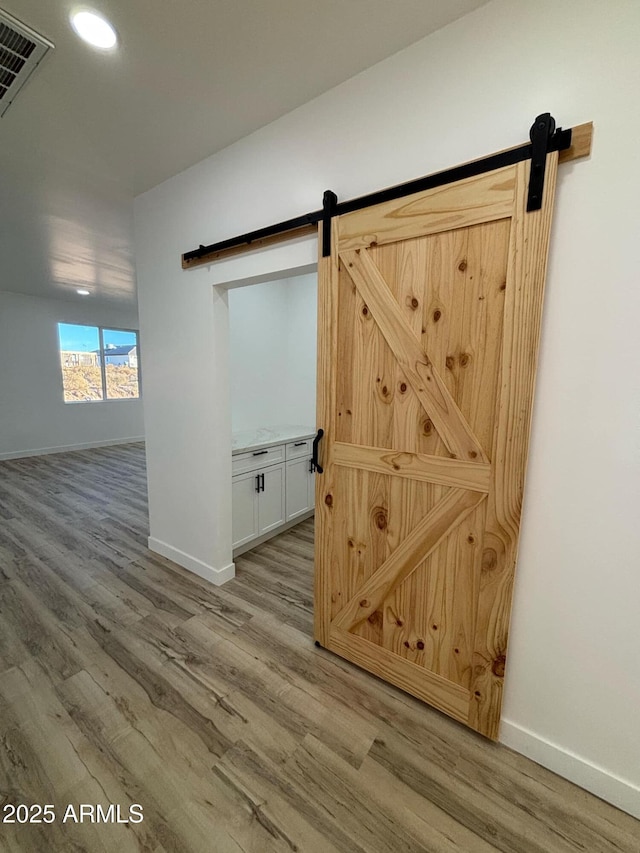 3627 W Palmaire Ave, Phoenix, AZ 85051 - detailed view of a barn door, wood finished floors, baseboards, and recessed lighting