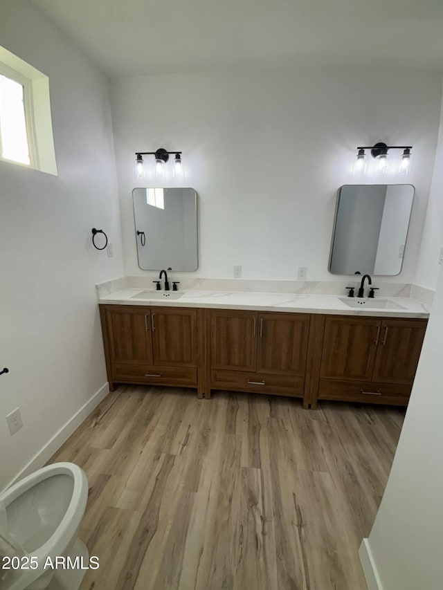 3627 W Palmaire Ave, Phoenix, AZ 85051 - full bathroom featuring wood finished floors, double vanity, baseboards, and toilet
