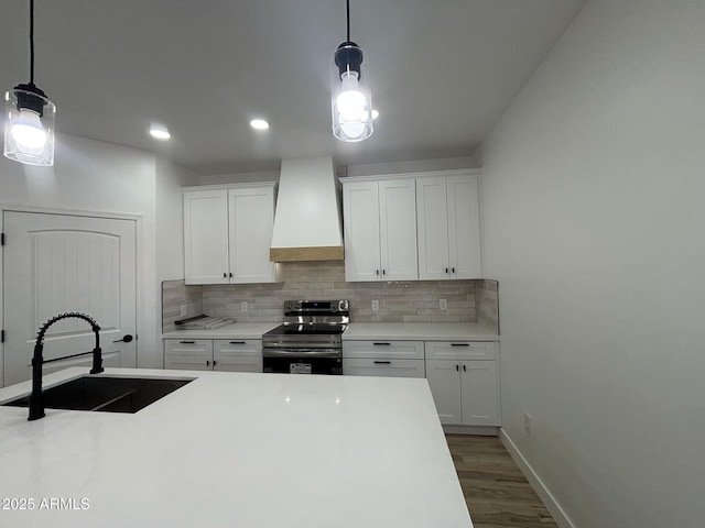 3627 W Palmaire Ave, Phoenix, AZ 85051 - kitchen with stainless steel range with electric cooktop, wall chimney exhaust hood, a sink, decorative backsplash, and recessed lighting