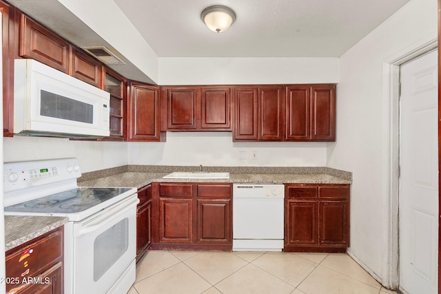 kitchen with white appliances, sink, and light tile patterned floors