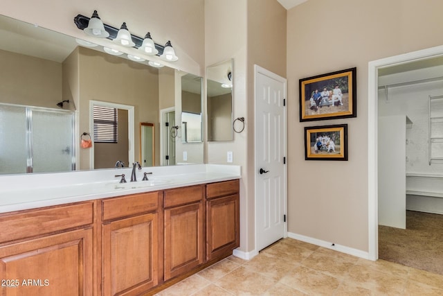 16758 W Apache St, Goodyear, AZ 85338 - bathroom with a stall shower, vanity, a spacious closet, and baseboards