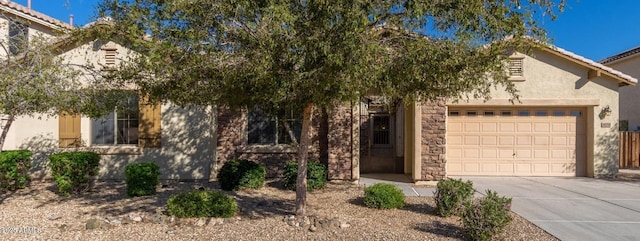 16758 W Apache St, Goodyear, AZ 85338 - view of property hidden behind natural elements featuring driveway, a garage, and stucco siding