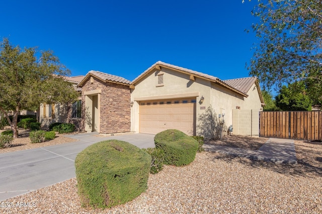 16758 W Apache St, Goodyear, AZ 85338 - ranch-style home with an attached garage, stucco siding, driveway, a tiled roof, and stone siding