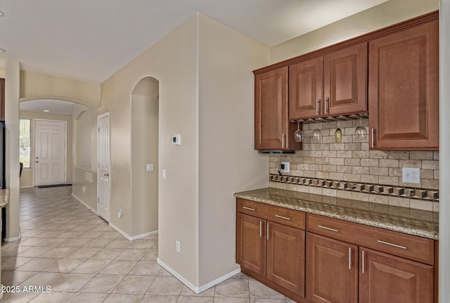 81 E Rock Wren Dr, San Tan Valley, AZ 85143 - kitchen with tasteful backsplash, arched walkways, light tile patterned floors, and stone countertops
