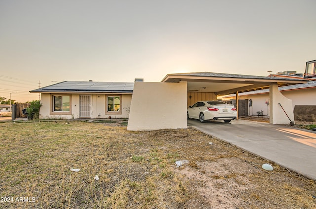 13802 N 37th Dr, Phoenix, AZ 85053 - view of front facade with an attached carport, solar panels, concrete driveway, and stucco siding