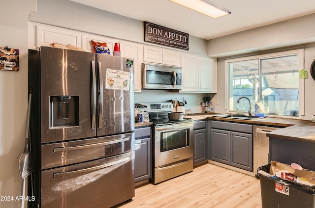 13802 N 37th Dr, Phoenix, AZ 85053 - kitchen featuring appliances with stainless steel finishes, gray cabinets, white cabinetry, light wood-style floors, and dark countertops