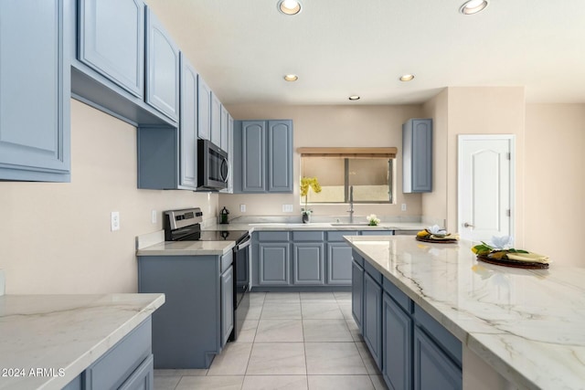 kitchen featuring light stone countertops, stainless steel appliances, sink, blue cabinetry, and light tile patterned floors