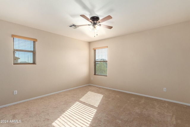 carpeted spare room featuring ceiling fan