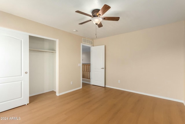 unfurnished bedroom with ceiling fan, a closet, and light wood-type flooring