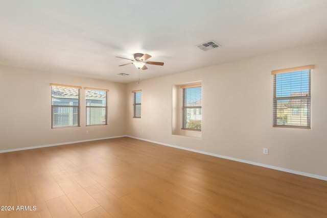 empty room with ceiling fan and light hardwood / wood-style floors