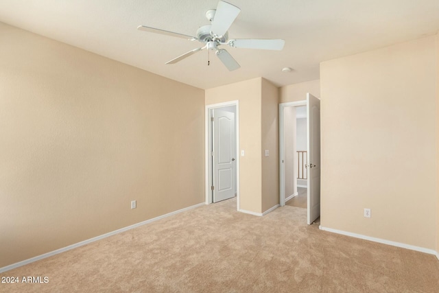 unfurnished bedroom featuring light carpet and ceiling fan