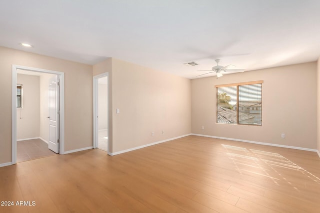 empty room with ceiling fan and light hardwood / wood-style floors