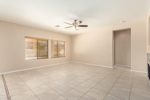 unfurnished room with ceiling fan and light tile patterned flooring