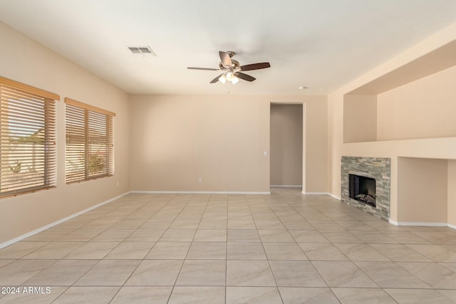 unfurnished living room with ceiling fan, light tile patterned floors, and a fireplace