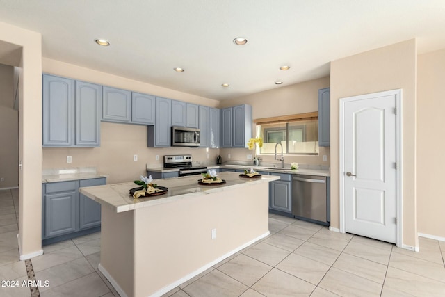 kitchen featuring a center island, sink, light tile patterned floors, and stainless steel appliances