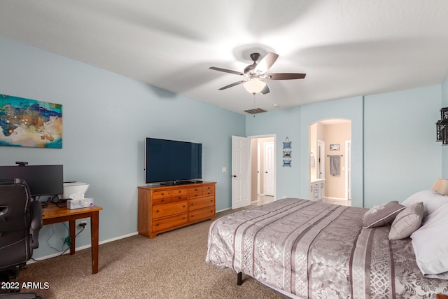 bedroom with light colored carpet, ceiling fan, and ensuite bath