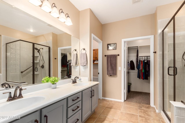 bathroom with tile patterned flooring, vanity, and an enclosed shower