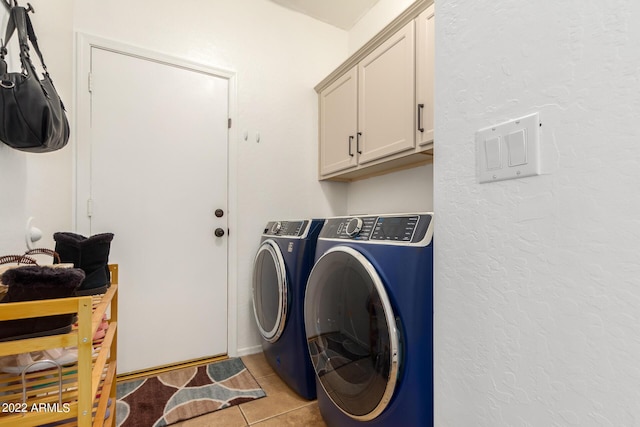 laundry room with cabinets, washer and dryer, and light tile patterned floors