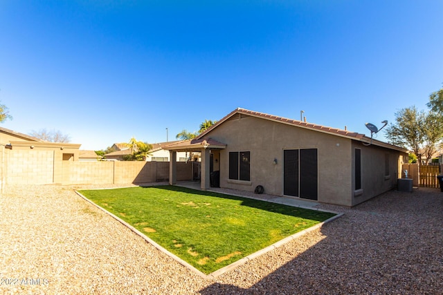 rear view of property featuring central AC and a lawn