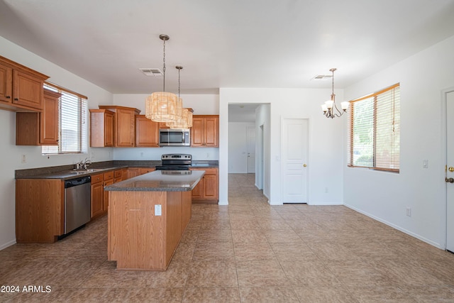 kitchen with a kitchen island, sink, hanging light fixtures, a notable chandelier, and stainless steel appliances