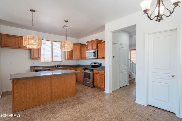 kitchen with stainless steel appliances, a kitchen island, sink, and pendant lighting