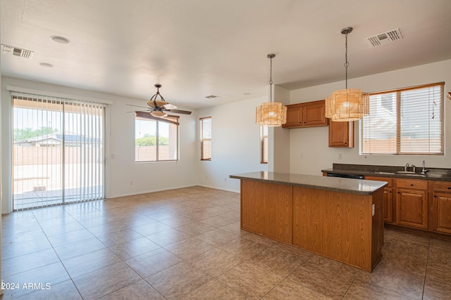 kitchen with pendant lighting, ceiling fan, a kitchen island, and light tile patterned floors