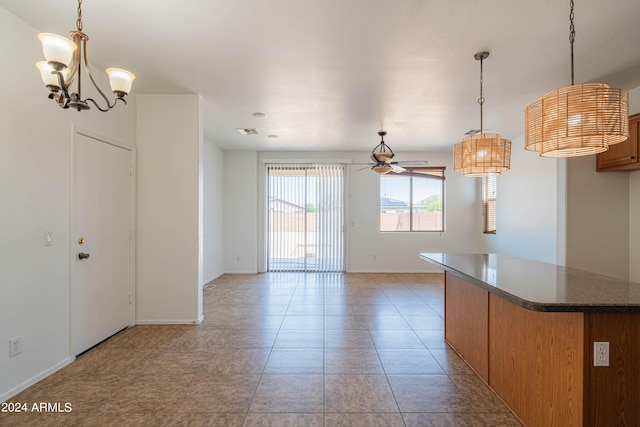 kitchen with pendant lighting, light tile patterned floors, and ceiling fan with notable chandelier