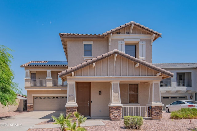 view of front of house with a porch, a garage, and solar panels