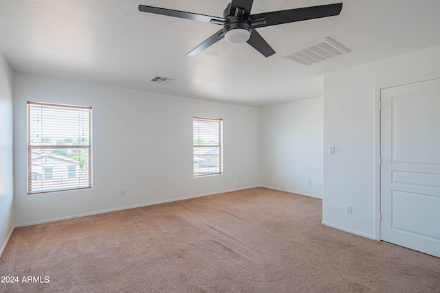 carpeted spare room with ceiling fan