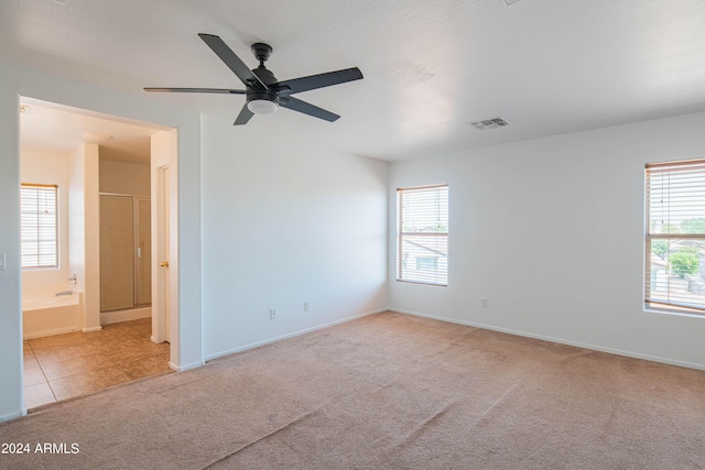 carpeted spare room featuring ceiling fan