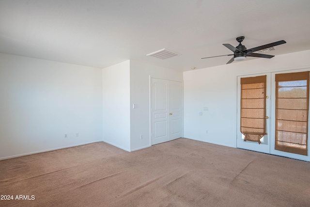 carpeted empty room with ceiling fan and french doors