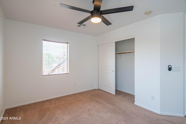 unfurnished bedroom featuring light carpet, ceiling fan, and a closet