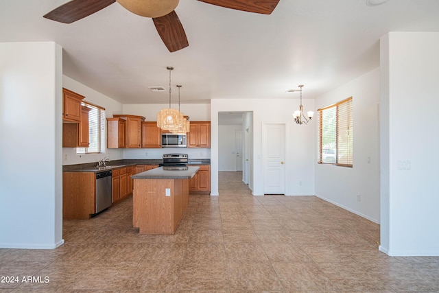 kitchen with a healthy amount of sunlight, appliances with stainless steel finishes, a center island, and decorative light fixtures