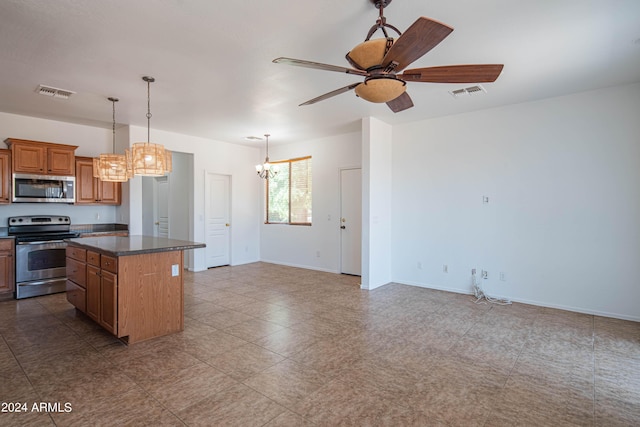 kitchen with a kitchen island, appliances with stainless steel finishes, ceiling fan with notable chandelier, and decorative light fixtures